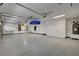 Spacious garage with storage cabinets, hanging racks, and epoxy flooring providing ample space for parking and storage at 7761 Cowboy Trl, Las Vegas, NV 89131