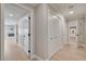 Hallway with multiple closets, white doors, and light wood flooring at 7761 Cowboy Trl, Las Vegas, NV 89131