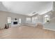 Expansive living room with a central fireplace, hardwood floors, and abundant natural light from large windows at 7761 Cowboy Trl, Las Vegas, NV 89131