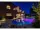 This captivating nighttime shot showcases the pool with vibrant lighting and a charming patio area at 7761 Cowboy Trl, Las Vegas, NV 89131