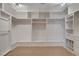 Spacious walk-in closet with custom shelving, ample hanging space, and hardwood floors at 7761 Cowboy Trl, Las Vegas, NV 89131