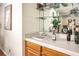 Wet bar features wood cabinets, tile countertop, sink, and open shelving with decorative items and mirrored backsplash at 8428 Apple Hill Ct, Las Vegas, NV 89128