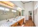 Spacious bathroom with a double sink vanity, large mirrors, and tile countertops, providing ample lighting at 8428 Apple Hill Ct, Las Vegas, NV 89128
