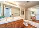 Well-lit bathroom featuring wood floors, a large mirror, and a shower with glass door at 8428 Apple Hill Ct, Las Vegas, NV 89128