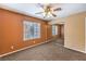Comfortable bedroom features a ceiling fan, large window, and mirrored closet doors at 8428 Apple Hill Ct, Las Vegas, NV 89128
