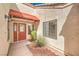 Welcoming front entrance showcasing a red awning, decorative door, and desert-style landscaping at 8428 Apple Hill Ct, Las Vegas, NV 89128