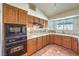Well-equipped kitchen with stainless steel appliances, warm wood cabinets, and tiled flooring at 8428 Apple Hill Ct, Las Vegas, NV 89128