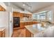 Eat-in kitchen boasts tile floors, warm wood cabinets, a spacious island, and stainless steel appliances at 8428 Apple Hill Ct, Las Vegas, NV 89128