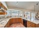 Bright kitchen featuring warm wood cabinets, ample counter space, stainless steel appliances, and a window over the sink at 8428 Apple Hill Ct, Las Vegas, NV 89128
