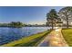 Scenic view of a lake with a walking path, surrounded by trees and well-maintained landscaping at 8428 Apple Hill Ct, Las Vegas, NV 89128