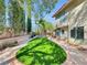Spacious backyard with a well-maintained lawn, mature trees, and a charming patio area, perfect for outdoor living at 8632 Skyward Ct, Las Vegas, NV 89145