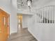 Bright foyer with hardwood flooring, white staircase, and a modern light fixture, offering a welcoming entrance at 8632 Skyward Ct, Las Vegas, NV 89145