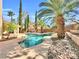 Inviting backyard with a sparkling blue pool, mature landscaping, and a peaceful patio area for outdoor enjoyment at 8632 Skyward Ct, Las Vegas, NV 89145
