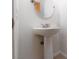 Simple powder room with white pedestal sink and round mirror, features modern fixtures at 9029 Tumblewood Ave, Las Vegas, NV 89143