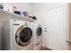 Functional laundry room with washer, dryer, and storage shelves for organization at 9029 Tumblewood Ave, Las Vegas, NV 89143