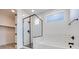 Bathroom with a glass shower and soaking tub, complemented by contemporary fixtures and white tile at 9265 Frazer St, Las Vegas, NV 89166