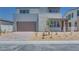 Two-story home with a modern exterior, stone accents, a brick driveway, and a two-car garage at 9265 Frazer St, Las Vegas, NV 89166