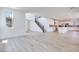 Open-concept living room with hardwood floors, abundant natural light, and a staircase leading to the upper level at 9265 Frazer St, Las Vegas, NV 89166