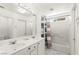 Bright, all-white bathroom featuring double sinks, a bathtub with shower, and ample storage at 9613 Eland Ct, Las Vegas, NV 89149