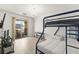 Well-lit bedroom with a TV, a bunk bed, and sliding glass door to a balcony at 9613 Eland Ct, Las Vegas, NV 89149
