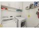 Well-organized laundry room with white front load washer and dryer and cabinet storage at 9613 Eland Ct, Las Vegas, NV 89149