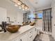 Bathroom features double sinks with decorative lighting and modern fixtures plus a shower and tub combination at 9718 Camino Capistrano Ln, Las Vegas, NV 89147