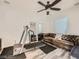 Versatile space for exercise, featuring a treadmill, leather couch and fan at 9718 Camino Capistrano Ln, Las Vegas, NV 89147