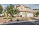 Charming two-story home with a desert landscaped front yard and a driveway leading to a two-car garage at 9718 Camino Capistrano Ln, Las Vegas, NV 89147