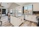 Well-lit kitchen featuring white cabinets, granite countertops, stainless steel appliances, and an island with a breakfast bar at 9718 Camino Capistrano Ln, Las Vegas, NV 89147