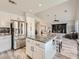 Open-concept kitchen boasts stainless steel appliances, granite countertops, and an island, flowing into a cozy living space at 9718 Camino Capistrano Ln, Las Vegas, NV 89147