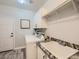 Well-lit laundry room with granite counters, washer, dryer, and storage cabinets at 9718 Camino Capistrano Ln, Las Vegas, NV 89147