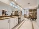 Luxurious bathroom features dual vanities, ample storage, and a walk-in shower with decorative tile at 9718 Camino Capistrano Ln, Las Vegas, NV 89147