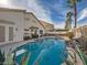 Sparkling swimming pool, mature landscaping, tall palm trees, and outdoor entertaining area at 9718 Camino Capistrano Ln, Las Vegas, NV 89147