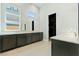Bathroom with double sink vanity with gray cabinets and a large mirror with three windows at 104 Tre Pietre St, Henderson, NV 89011