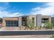 Modern home featuring desert landscaping, large front entry, and three car garage at 104 Tre Pietre St, Henderson, NV 89011