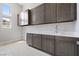 Bright laundry room with gray cabinets and white countertop with a view of the exterior at 104 Tre Pietre St, Henderson, NV 89011