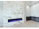 Modern living room with a fireplace, wet bar, recessed lighting, and beautiful tile floors at 104 Tre Pietre St, Henderson, NV 89011