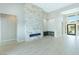 Open-concept living room featuring tile floors, a fireplace, wet bar, and natural light at 104 Tre Pietre St, Henderson, NV 89011
