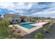 Inviting backyard pool with landscaping, and large windows on modern home with desert landscaping at 104 Tre Pietre St, Henderson, NV 89011