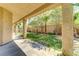 Inviting covered back patio overlooking a well-manicured lawn with mature trees and a charming block wall at 11478 Bargetto Ct, Las Vegas, NV 89141