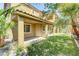 Beautiful backyard with manicured lawn, palm trees, and a covered patio at 11478 Bargetto Ct, Las Vegas, NV 89141
