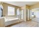 Bathroom featuring a jacuzzi tub and clear glass standing shower with a modern feel at 11478 Bargetto Ct, Las Vegas, NV 89141