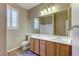 Bathroom featuring double sinks, wood cabinets, and a framed mirror at 11478 Bargetto Ct, Las Vegas, NV 89141