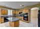 Bright kitchen offers an island, wood cabinets, granite countertops, and black appliances at 11478 Bargetto Ct, Las Vegas, NV 89141