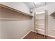 A view of a small walk-in closet with hanging clothes and shelving at 1470 Elizabeth Ave # 1, Las Vegas, NV 89119