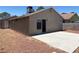 Back exterior showcasing a sliding glass door that opens onto a patio and desert landscaping at 1501 Wintergreen Dr, Las Vegas, NV 89128