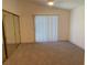 A bright bedroom with neutral carpet, large window and mirrored closet doors at 1501 Wintergreen Dr, Las Vegas, NV 89128