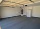Spacious garage with a water heater, refrigerator, and ample storage space with a freshly painted floor at 1501 Wintergreen Dr, Las Vegas, NV 89128