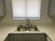Close up of stainless steel sink, solid surface countertops and light gray cabinetry at 1501 Wintergreen Dr, Las Vegas, NV 89128