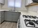 The kitchen features gray cabinetry, stone countertops and stainless sink at 1501 Wintergreen Dr, Las Vegas, NV 89128